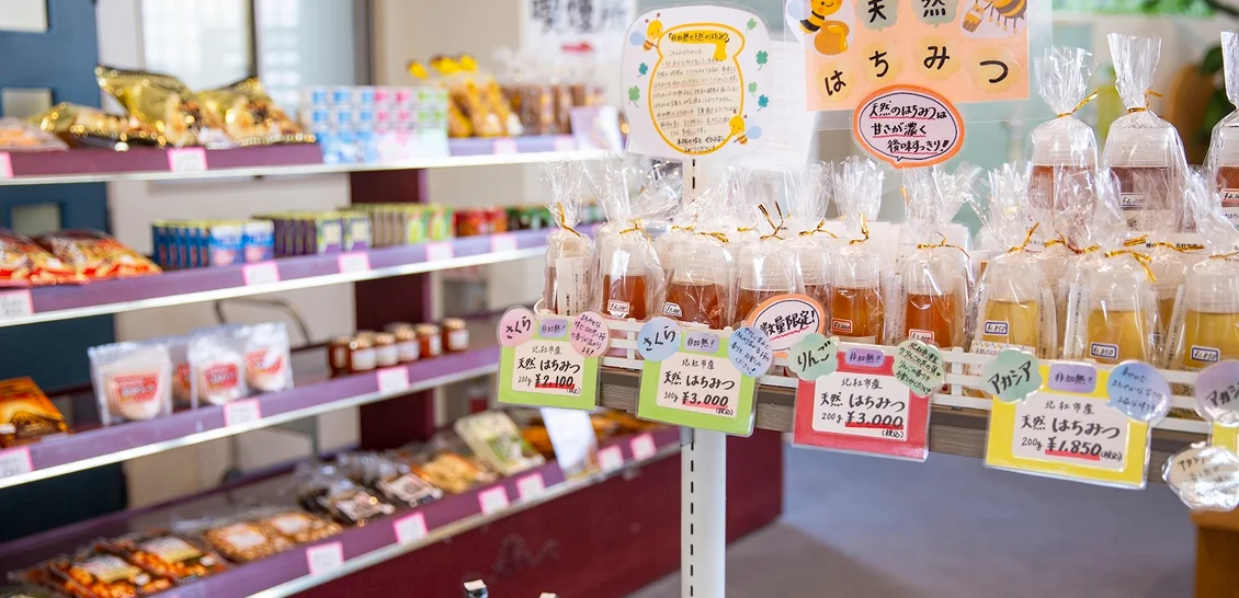 地元の特産品や飲み物、お菓子などが並ぶ明るい売店コーナーの棚