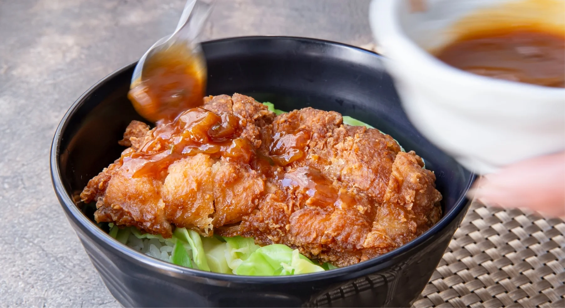 カツ丼にソースをかけている様子